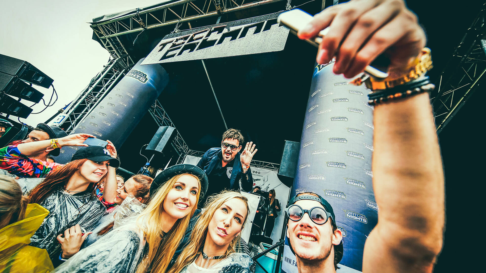 Fans machen vor einer Festivalbühne ein Selfie